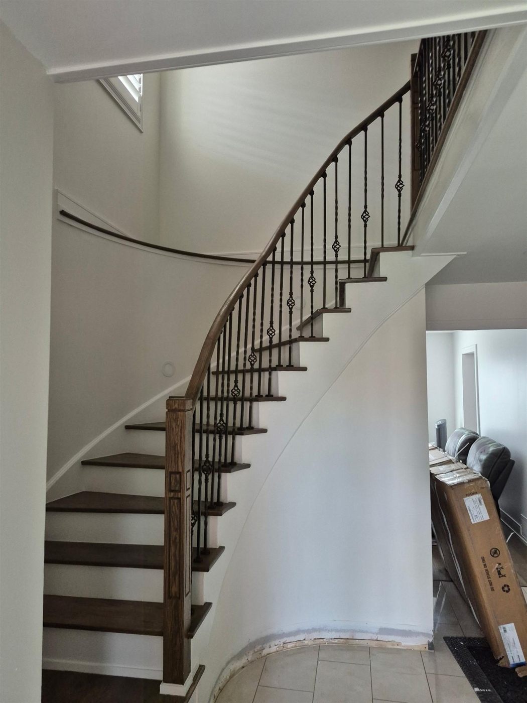 Curved wood and wrought iron grand staircase