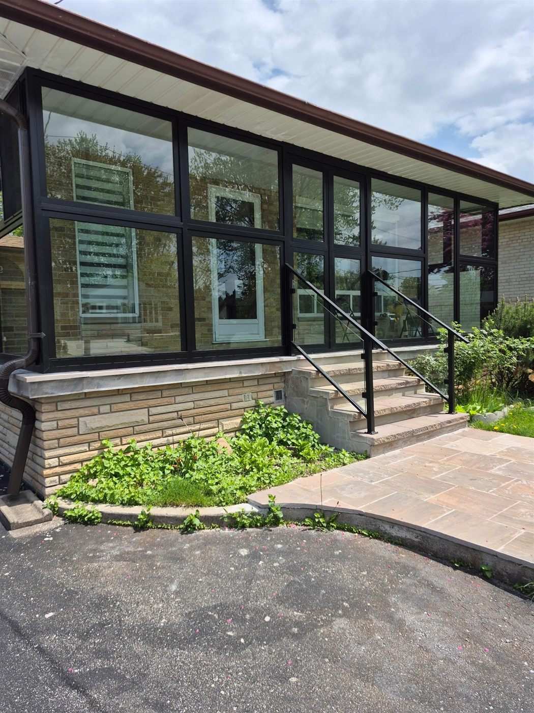 Glass and aluminum entry railing on stone steps