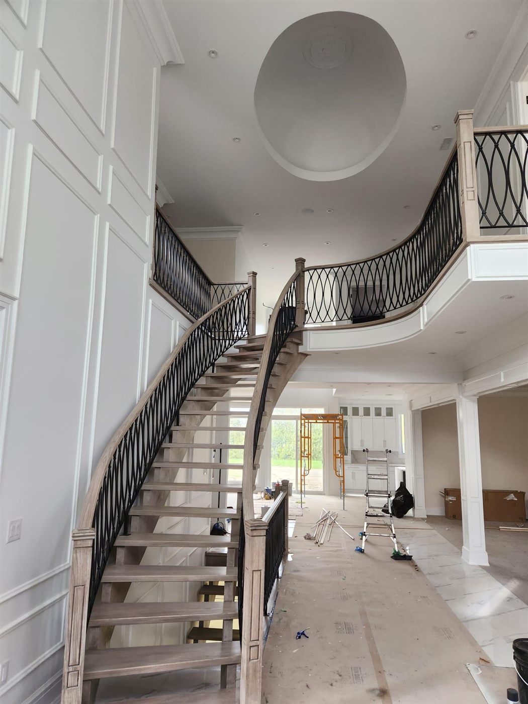 Grand dual staircase with ornate iron balustrade
