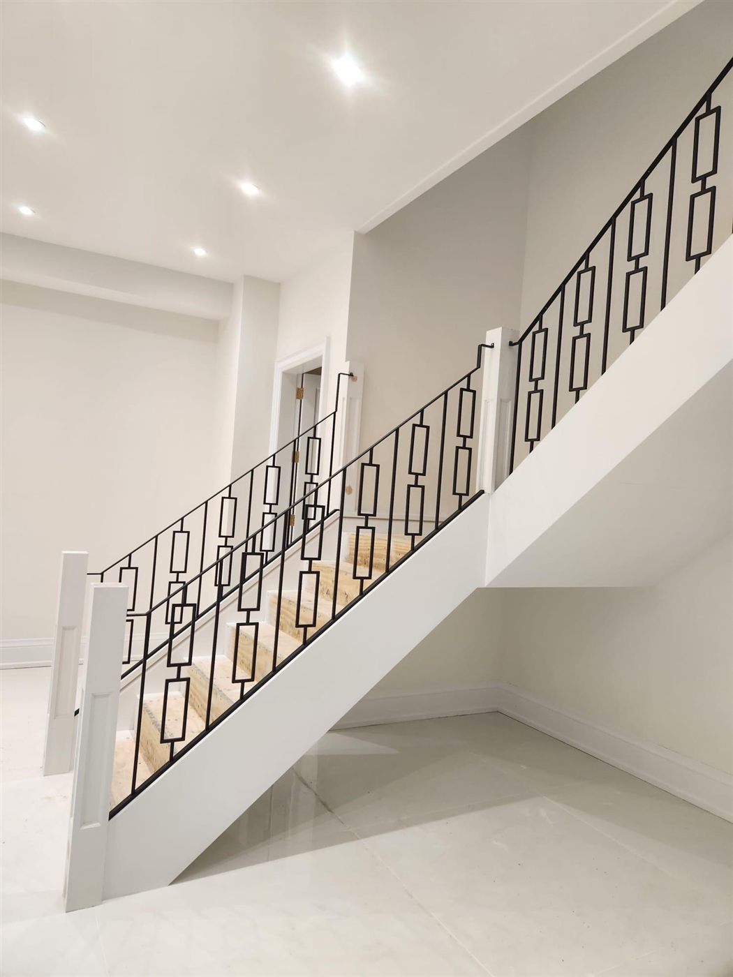 Modern iron staircase with geometric railing pattern