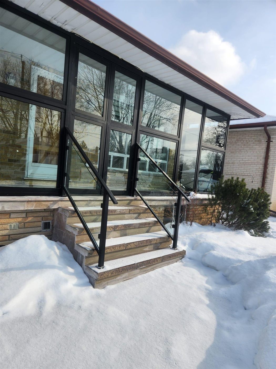 Aluminum entry railing on stone steps in winter